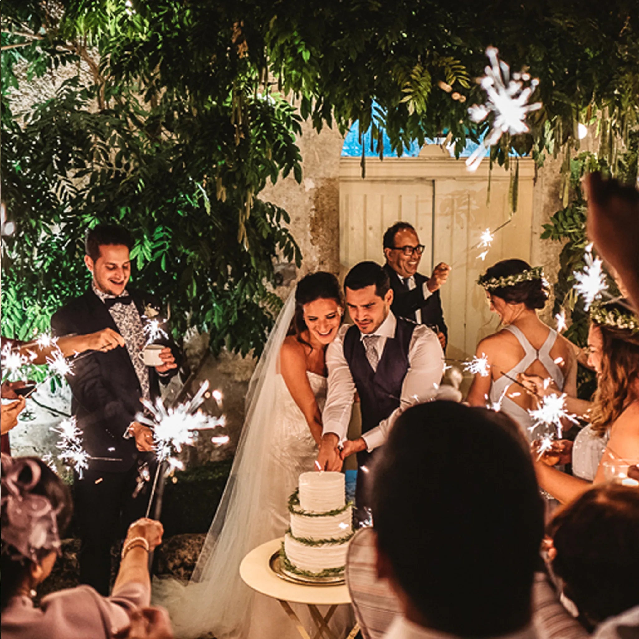 cutting the wedding cake with sparklers at wedding