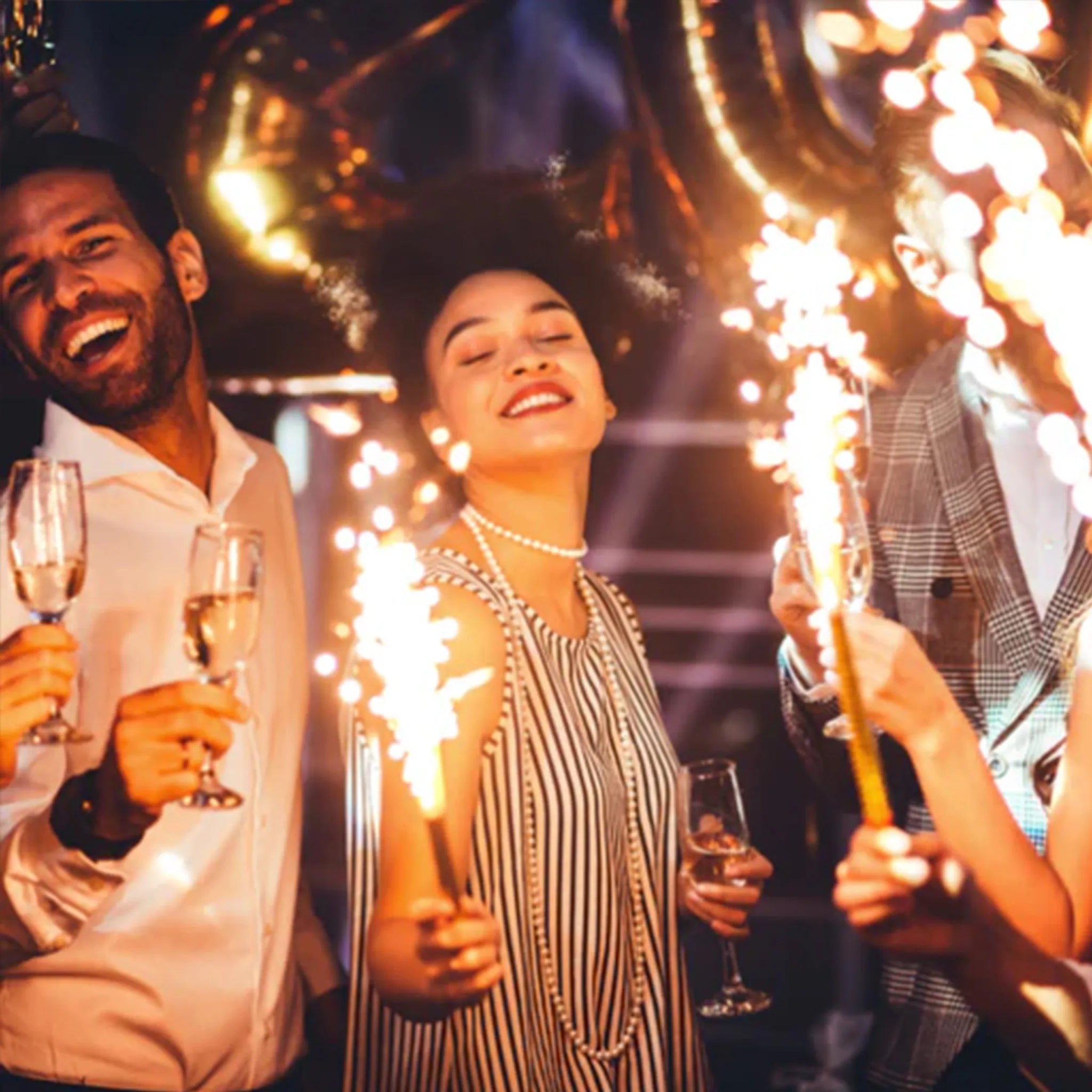 People celebrating with sparklers and drinks at a party